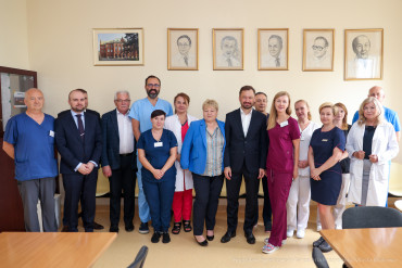 Prezydent Krakowa stoi przodem w grupie z Dyrekcją Szpitala i przedstawicielami personelu.