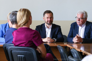 Na zdjęciu siedzi Prezydent Krakowa, obok niego Z-ca Miasta Krakowa. Na przeciwko nich, tyłem do zdjęcia siedzi kobieta.