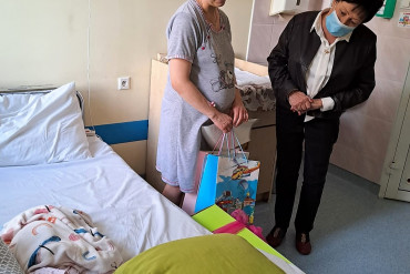 Mama z Panią Dyrektor patrzą na noworodka.