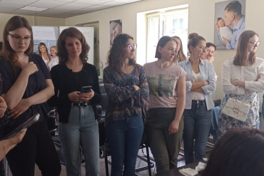 W linii stoi grupa kobiet słuchająca wykładu.