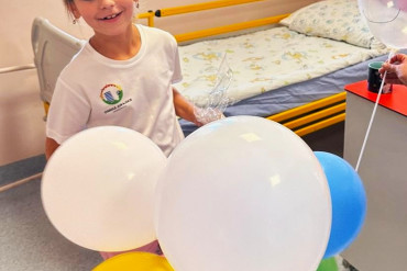 Dziewczynka patrzy na kolorowe balony.